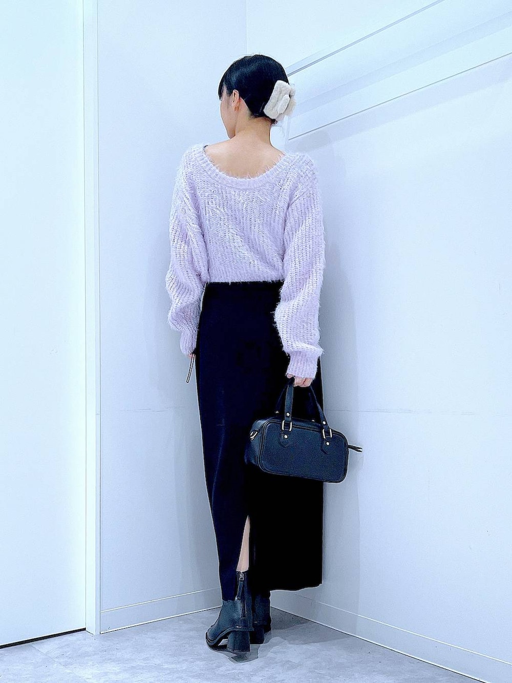 ブラック系のブーツ、ブラック系のショルダーバッグ、ブラック系のスカートを着用したレディースの冬コーディネートの5枚目の写真