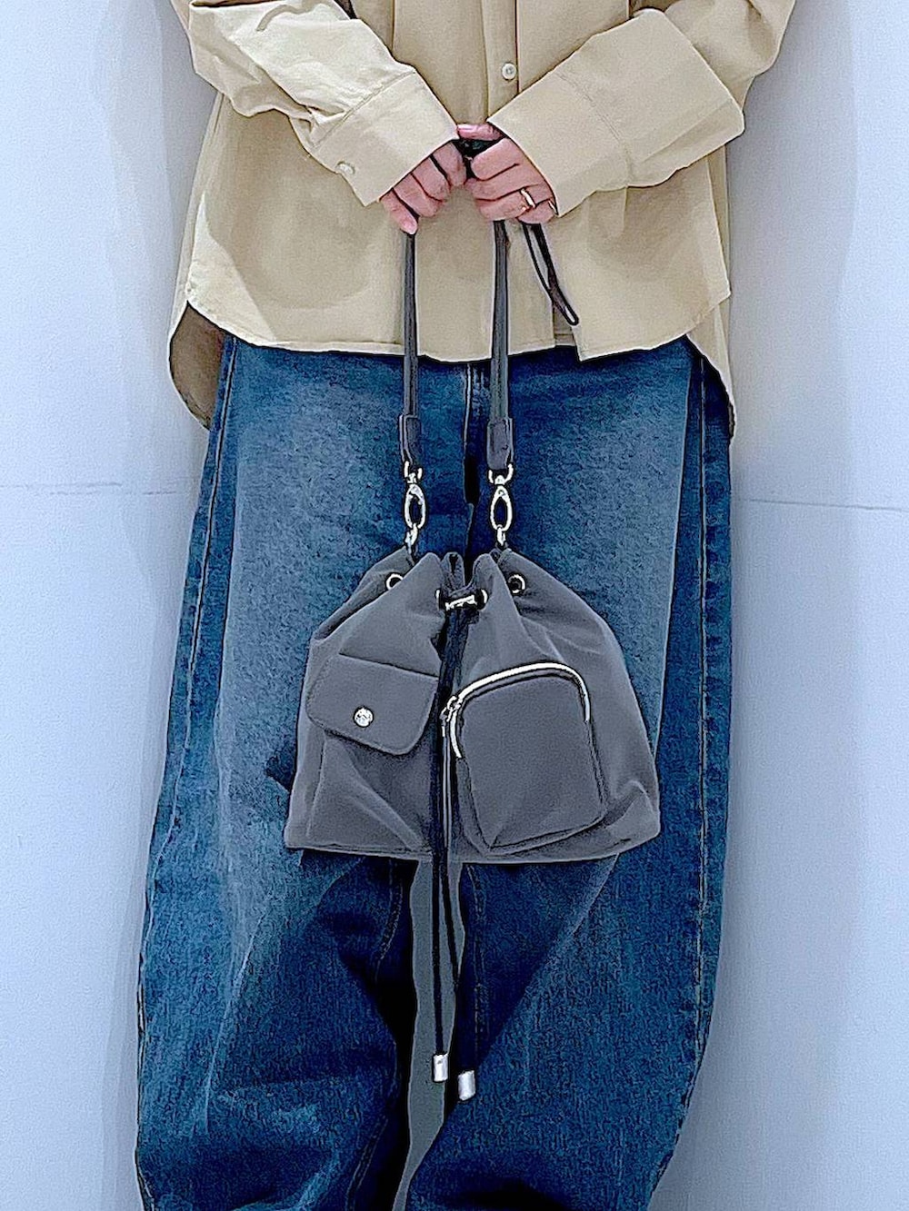 ブルー系のデニムパンツ、グレー系のショルダーバッグ、ベージュ系のその他トップスを着用したレディースの春コーディネートの9枚目の写真