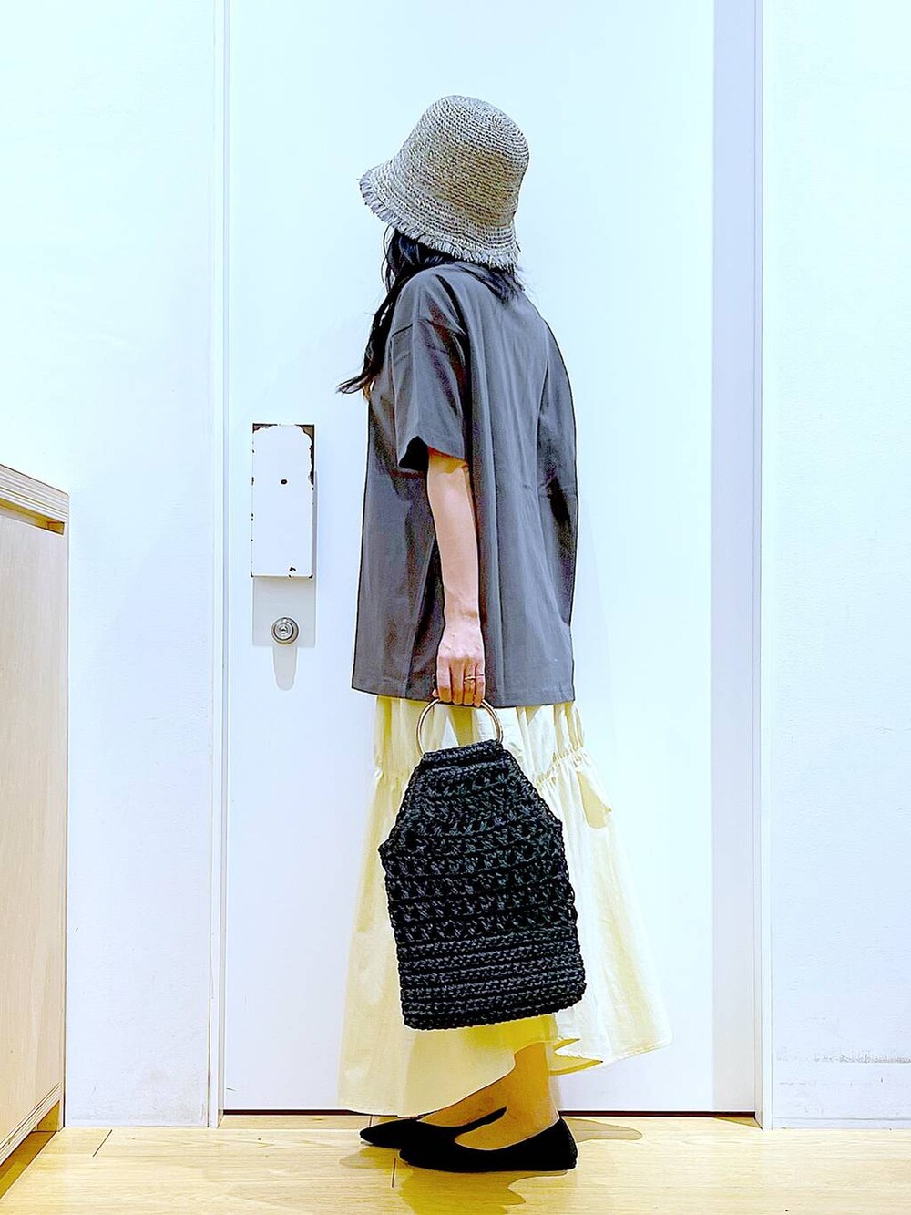 ブラック系のパンプス、グレー系のTシャツ/カットソー、ブラック系のハンドバッグを着用したレディースの春コーディネートの3枚目の写真