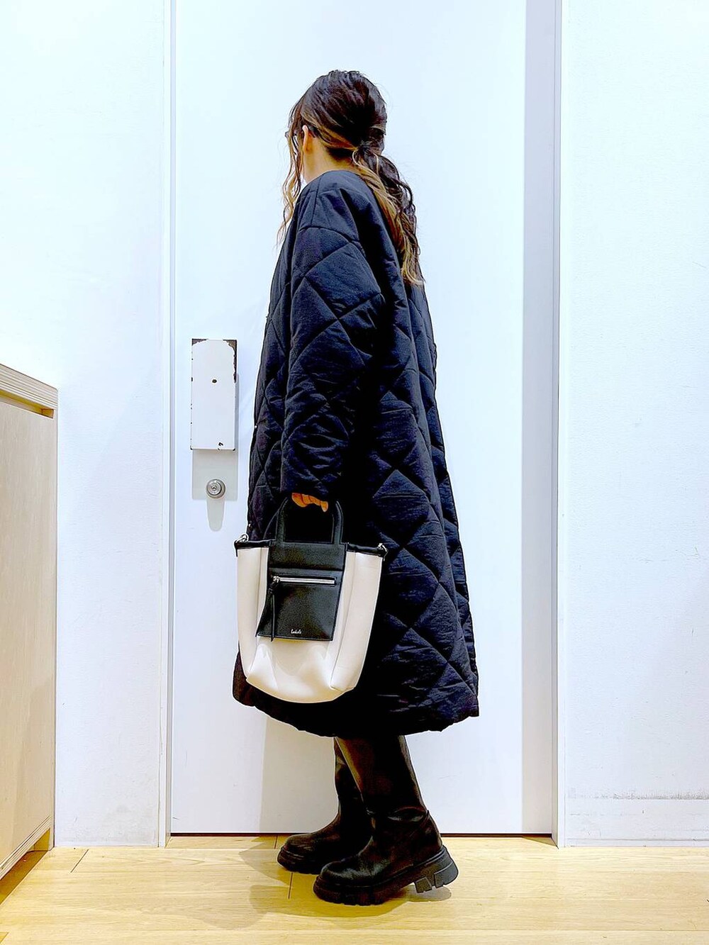 ブラック系のブーツ、ベージュ系のTシャツ/カットソー、ブラック系のその他パンツを着用したレディースの冬コーディネートの3枚目の写真