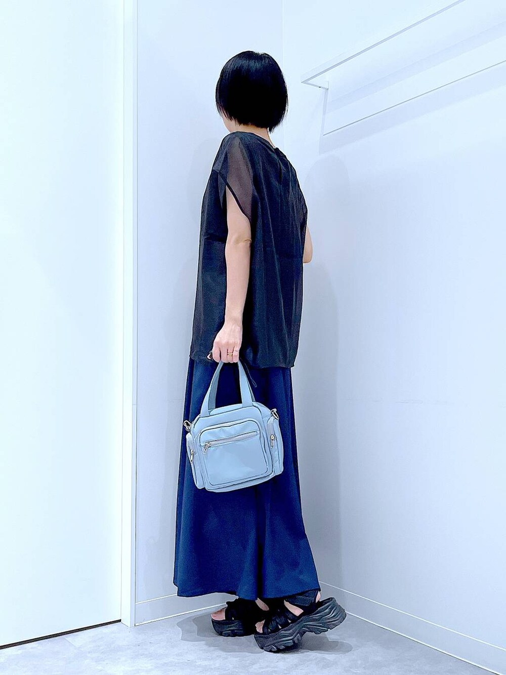 ブラック系のスニーカー、ブルー系のショルダーバッグ、ブルー系のその他パンツを着用したレディースの夏コーディネートの3枚目の写真