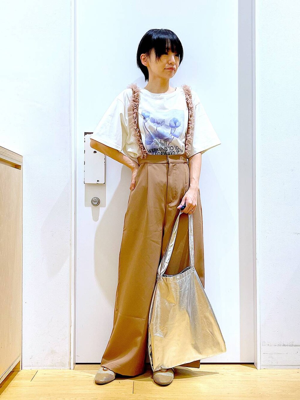 シルバー系のトートバッグ、ベージュ系のパンプス、ブラウン系のその他パンツを着用したレディースの春コーディネートの2枚目の写真