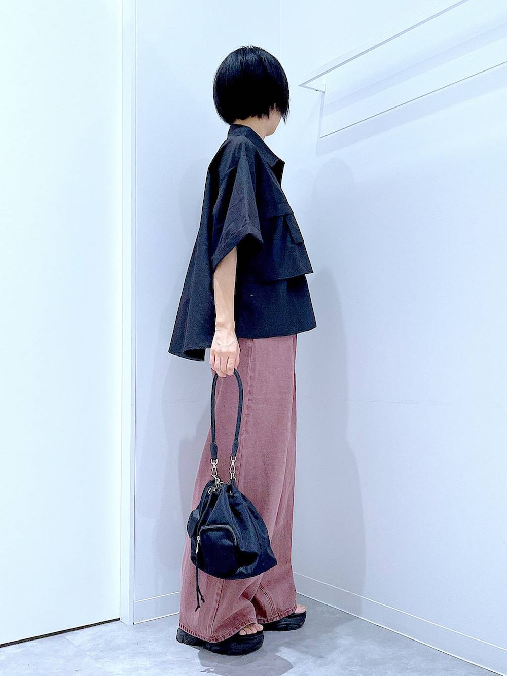 ブラック系のスニーカー、ブラック系のショルダーバッグ、ブラック系のシャツ/ブラウスを着用したレディースの秋コーディネートの4枚目の写真