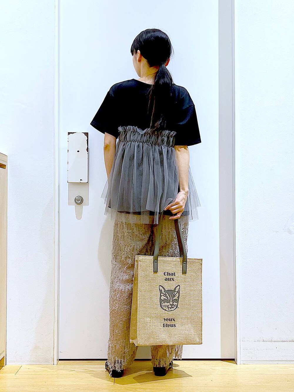 ブラック系のTシャツ/カットソー、ブラック系のパンプス、グレー系のトートバッグを着用したレディースの夏コーディネートの5枚目の写真