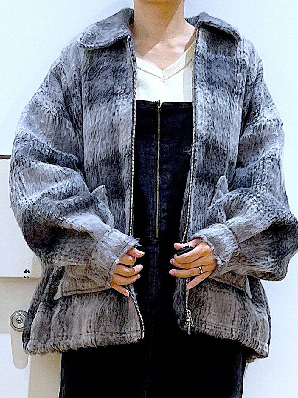 グレー系のジャンパースカート、ブラック系のブーツ、ブラック系のショルダーバッグを着用したレディースの冬コーディネートの7枚目の写真