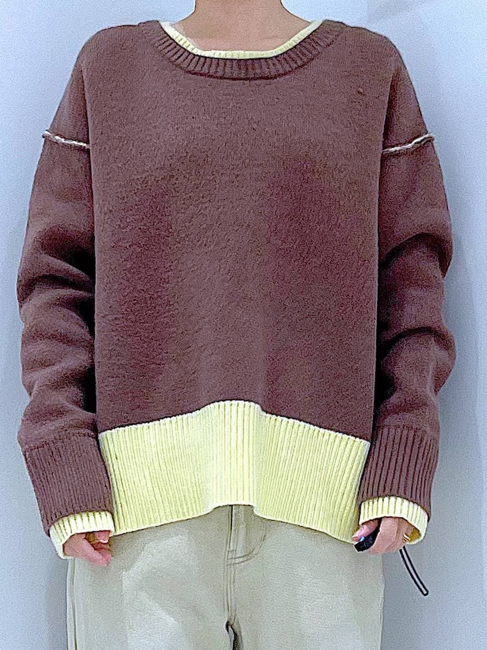 ブラウン系のニット/セーター、ベージュ系のデニムパンツ、ブラウン系のショルダーバッグを着用したレディースの冬コーディネートの7枚目の写真