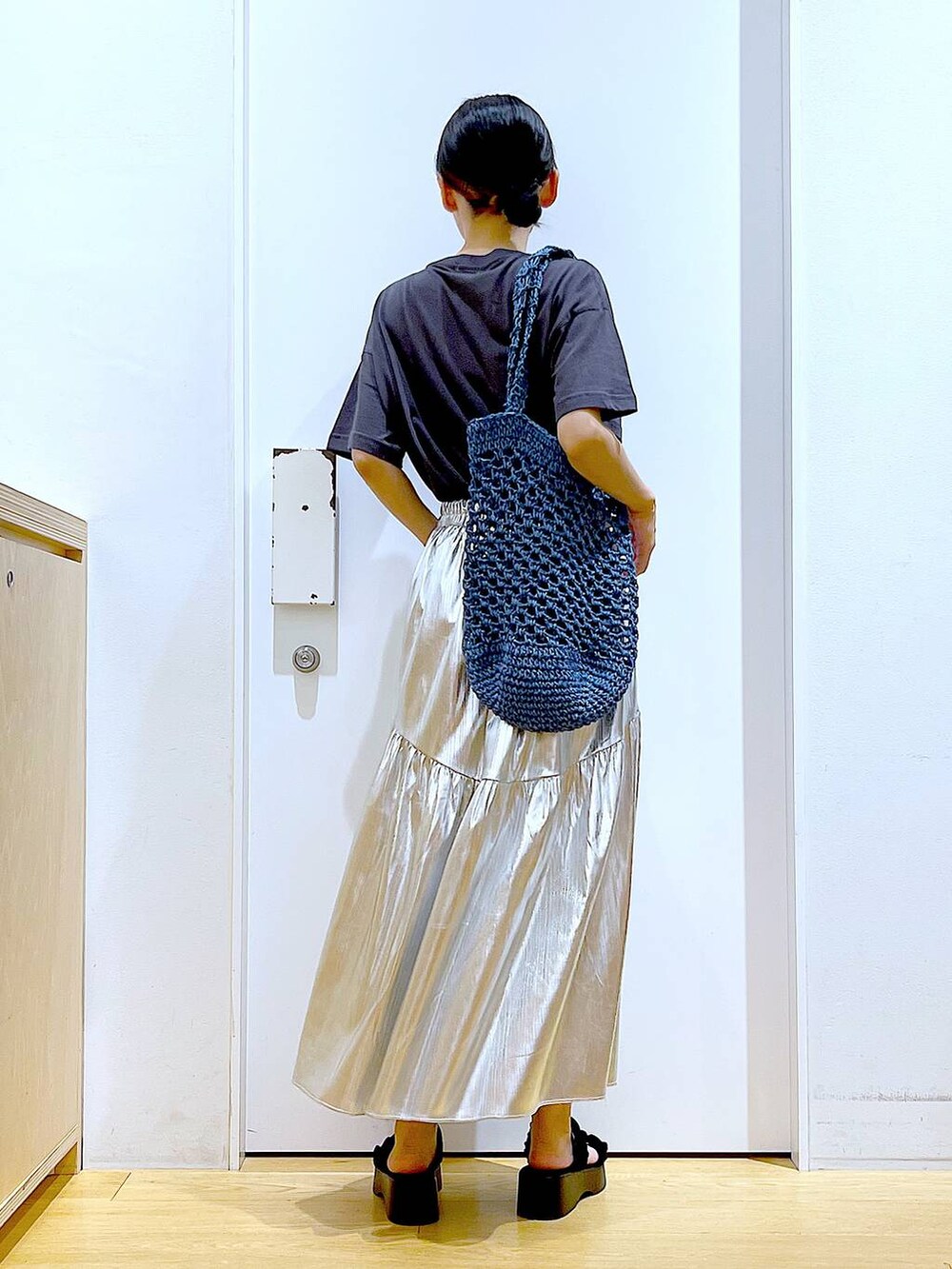 ブラック系のサンダル、シルバー系のスカート、ブルー系のトートバッグを着用したレディースの夏コーディネートの5枚目の写真