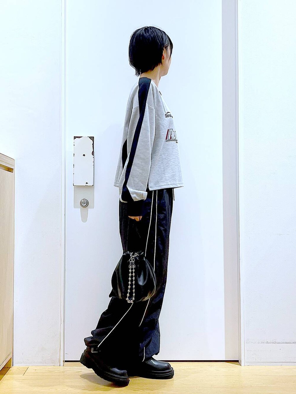 ブラック系のショルダーバッグ、ブラック系のブーツ、グレー系のTシャツ/カットソーを着用したレディースの秋コーディネートの4枚目の写真