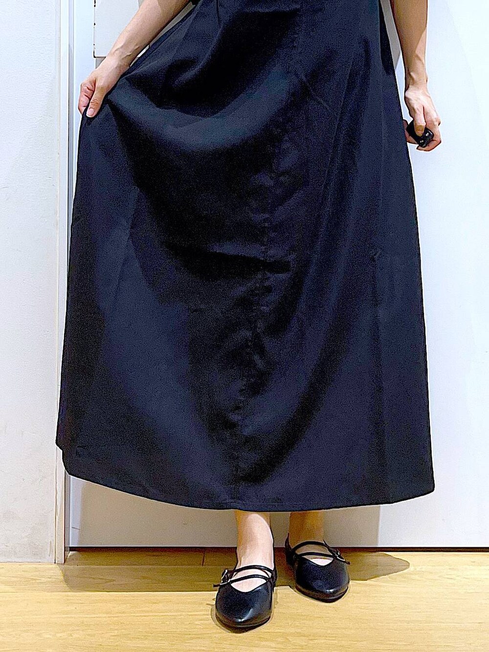 イエロー系のハンドバッグ、ブラック系のワンピース、ブラック系のパンプスを着用したレディースの秋コーディネートの9枚目の写真