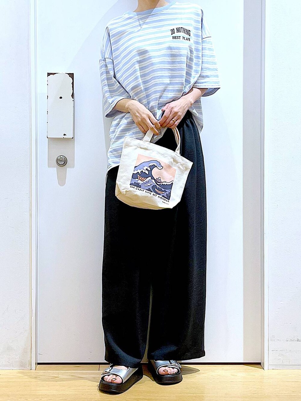 シルバー系のサンダル、その他のトートバッグ、ブルー系のTシャツ/カットソーを着用したレディースの夏コーディネートの6枚目の写真