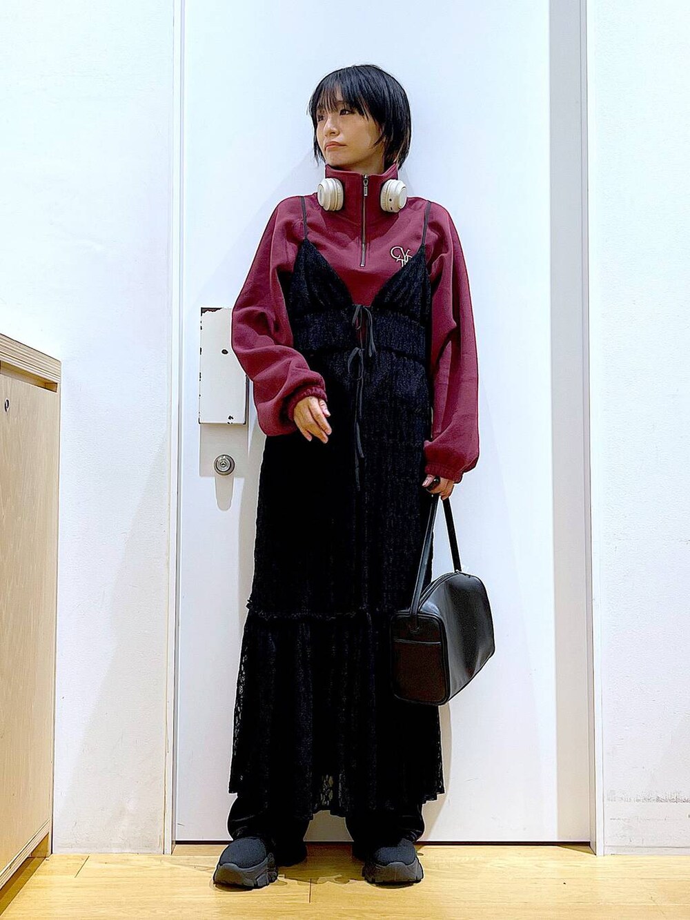 ブラック系のショルダーバッグ、ブラック系のワンピース、ブラック系のブーツを着用したレディースの冬コーディネートの2枚目の写真