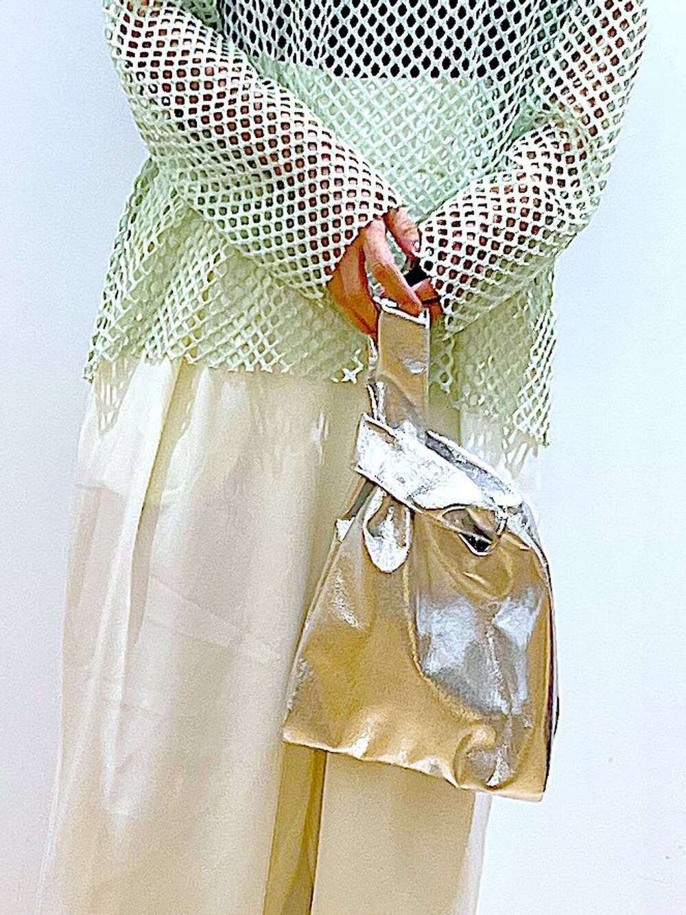 シルバー系のショルダーバッグ、グリーン系のTシャツ/カットソー、ホワイト系のパンプスを着用したレディースの春コーディネートの9枚目の写真