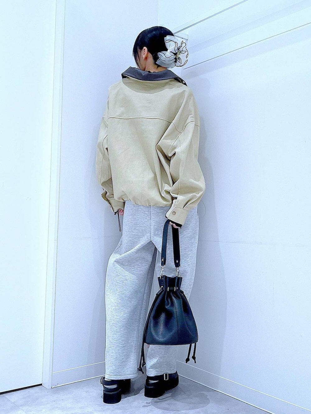 ブラック系のサンダル、ブラック系のショルダーバッグ、ベージュ系のブルゾンを着用したレディースの春コーディネートの5枚目の写真