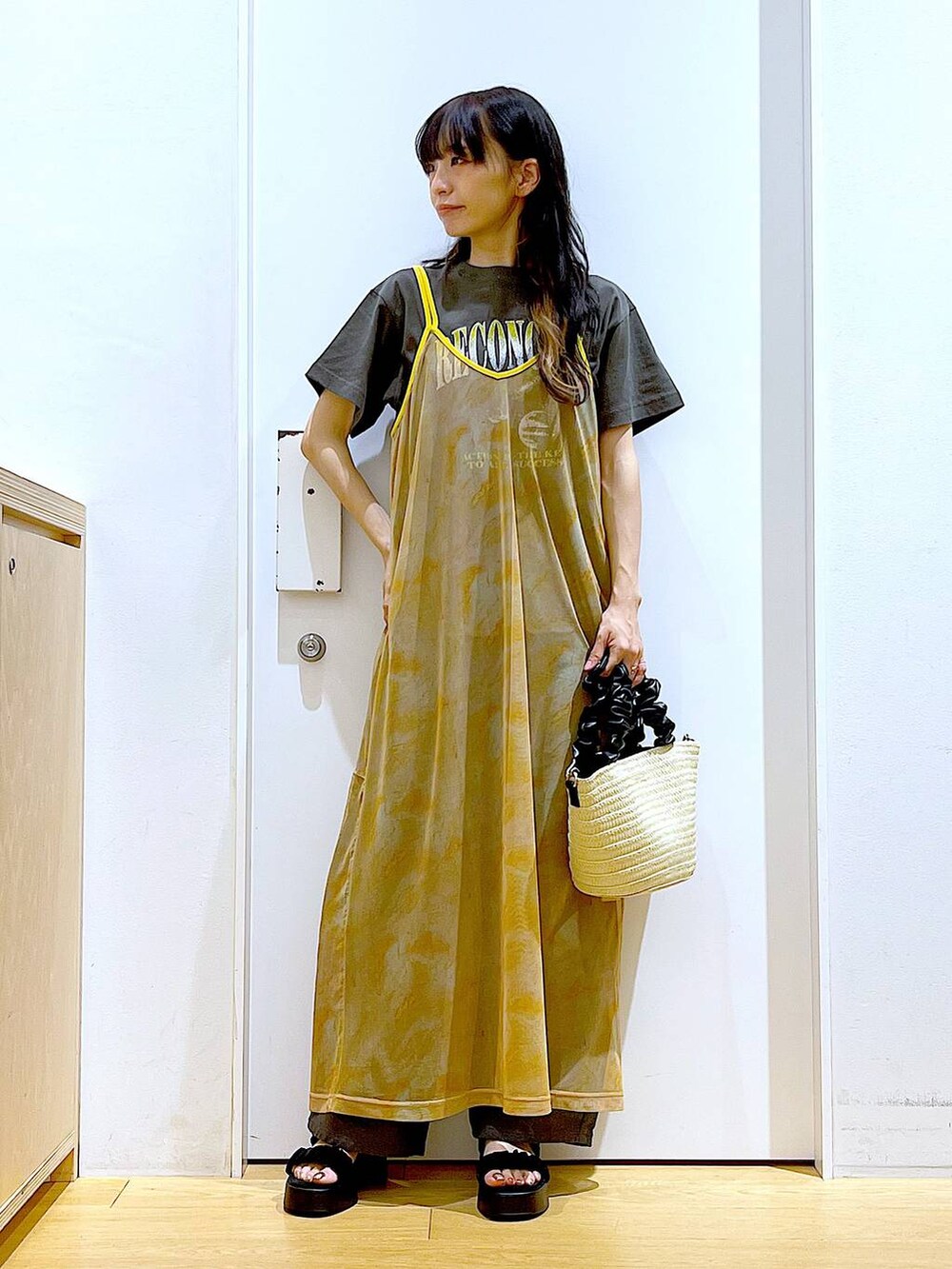 グレー系のその他パンツ、ホワイト系のショルダーバッグ、オレンジ系のワンピースを着用したレディースの夏コーディネートの2枚目の写真