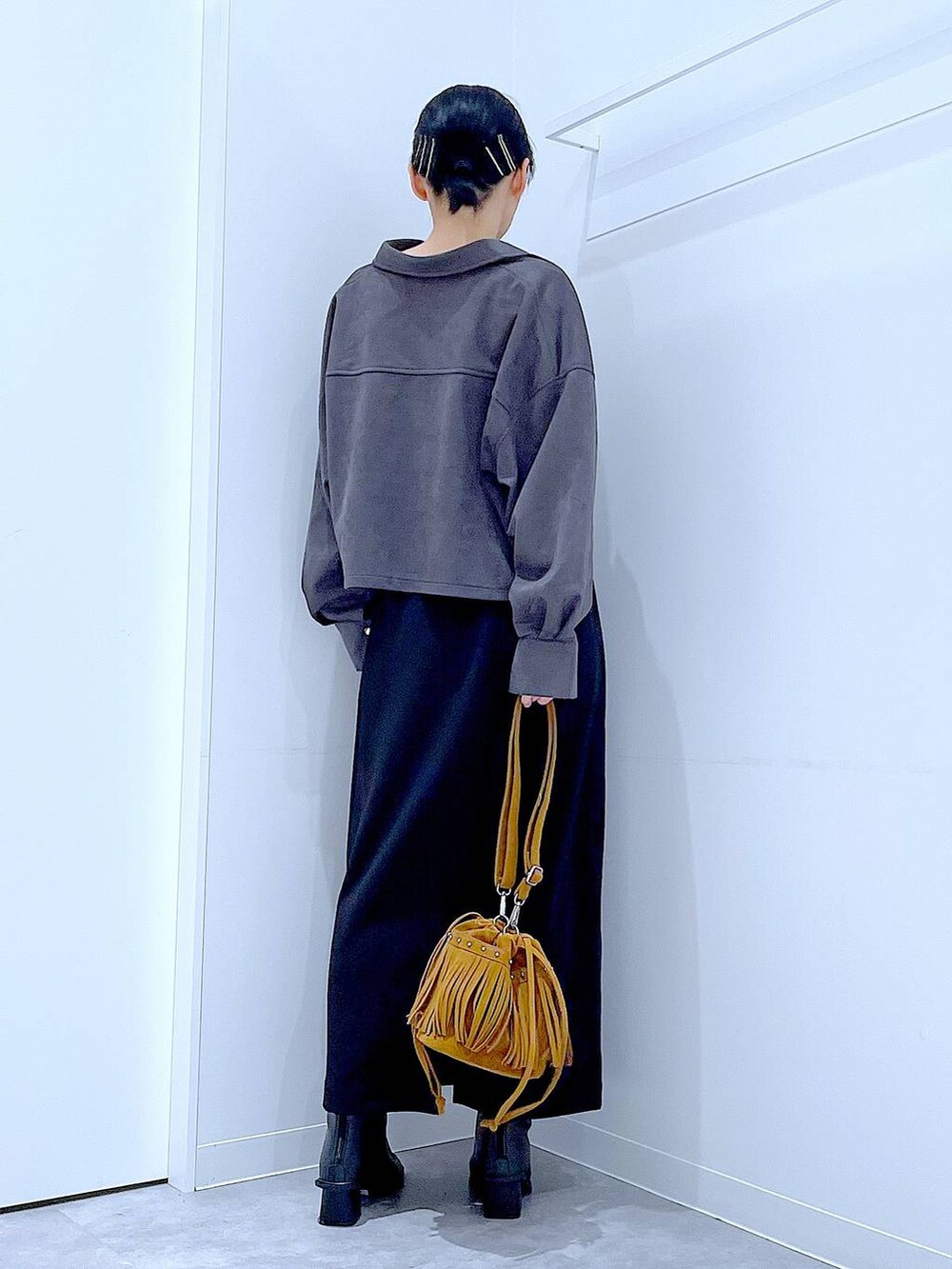 ブラック系のスカート、ブラック系のブーツ、グレー系のシャツ/ブラウスを着用したレディースの秋コーディネートの5枚目の写真