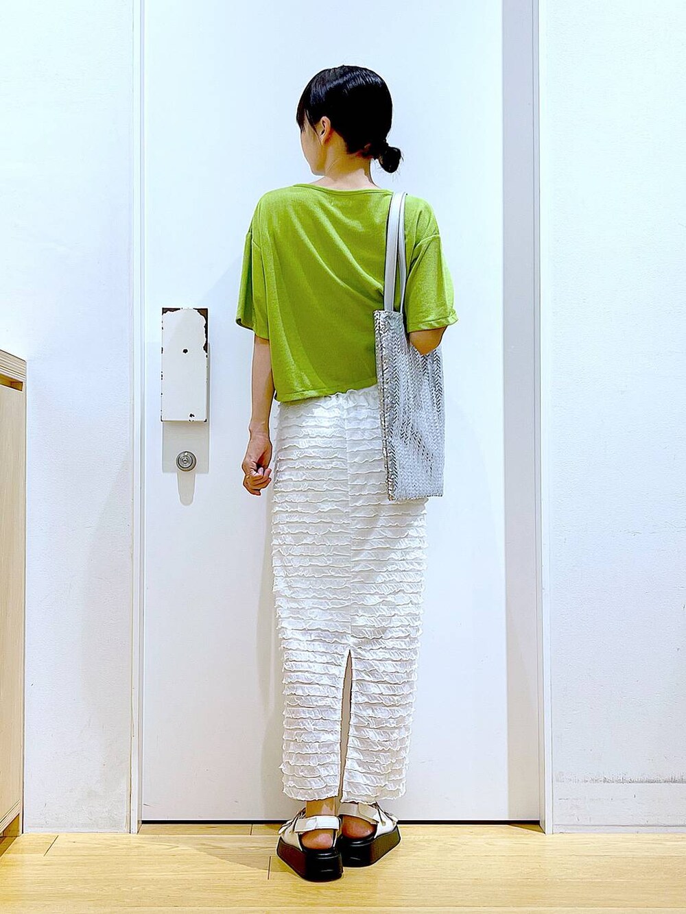 ホワイト系のサンダル、シルバー系のトートバッグ、ホワイト系のスカートを着用したレディースの秋コーディネートの5枚目の写真