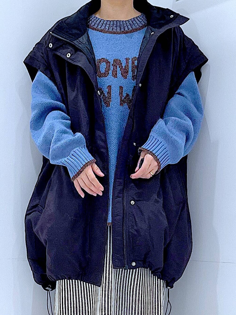 ブラック系のブルゾン、ベージュ系のスカート、ブラック系のブーツを着用したレディースの冬コーディネートの7枚目の写真