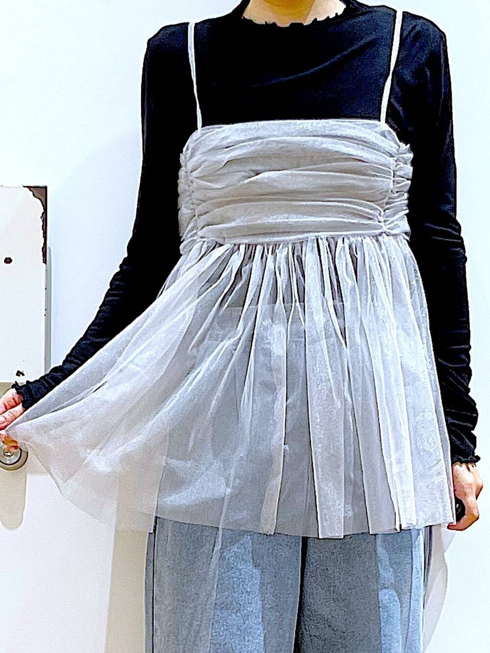 ブルー系のデニムパンツ、ピンク系のショルダーバッグ、ホワイト系のパンプスを着用したレディースの春コーディネートの7枚目の写真