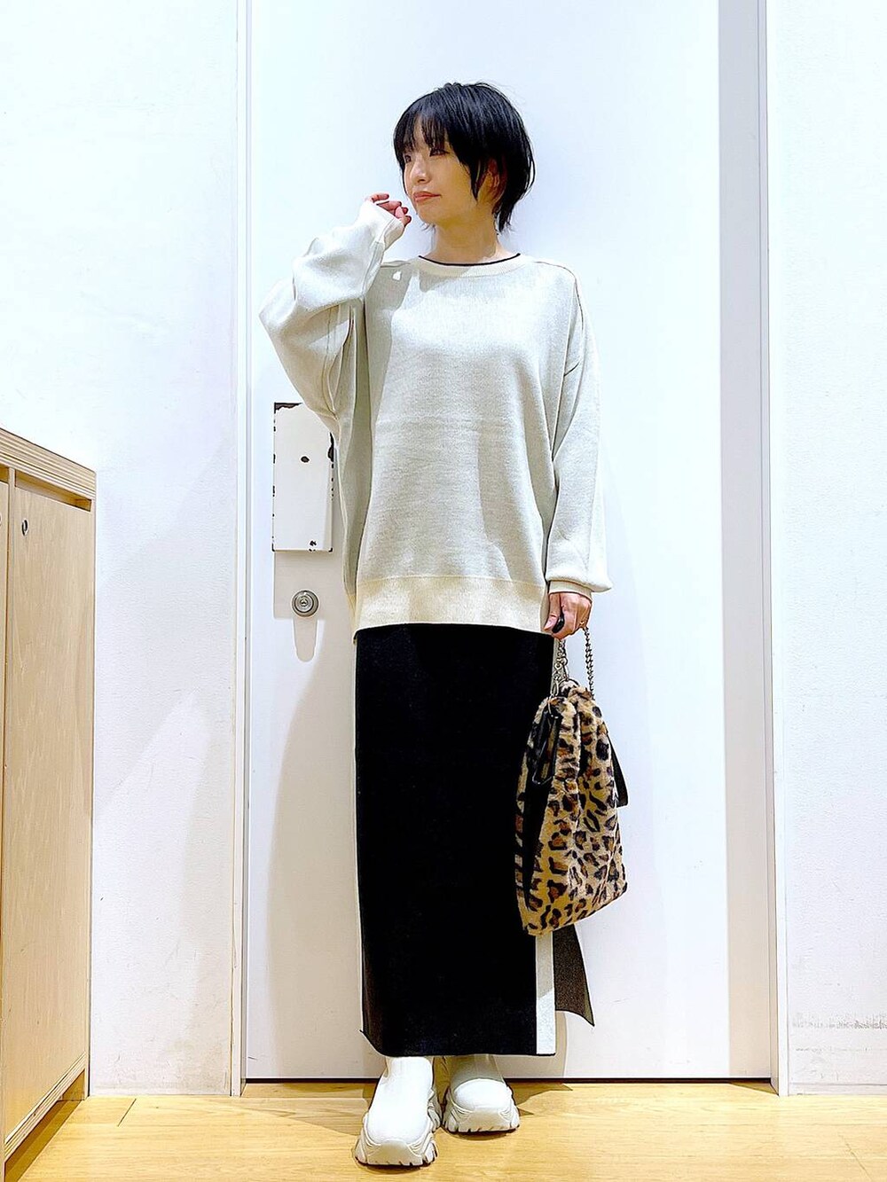 ベージュ系のニット/セーター、その他のショルダーバッグ、ブラック系のスカートを着用したレディースの冬コーディネートの2枚目の写真