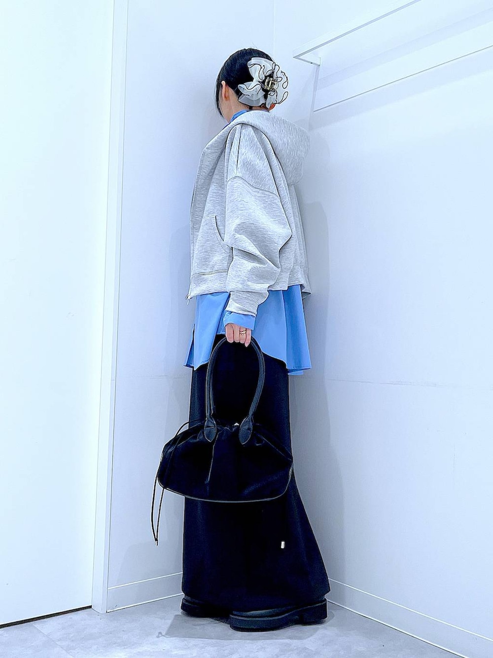 ブラック系のハンドバッグ、ブラック系のスカート、ブラック系のサンダルを着用したレディースの冬コーディネートの3枚目の写真