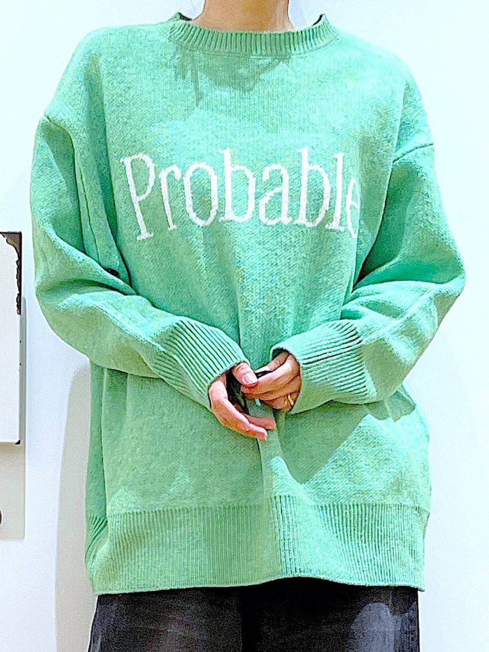 ブラック系のショルダーバッグ、ブラック系のブーツ、ブラック系のデニムパンツを着用したレディースの冬コーディネートの7枚目の写真