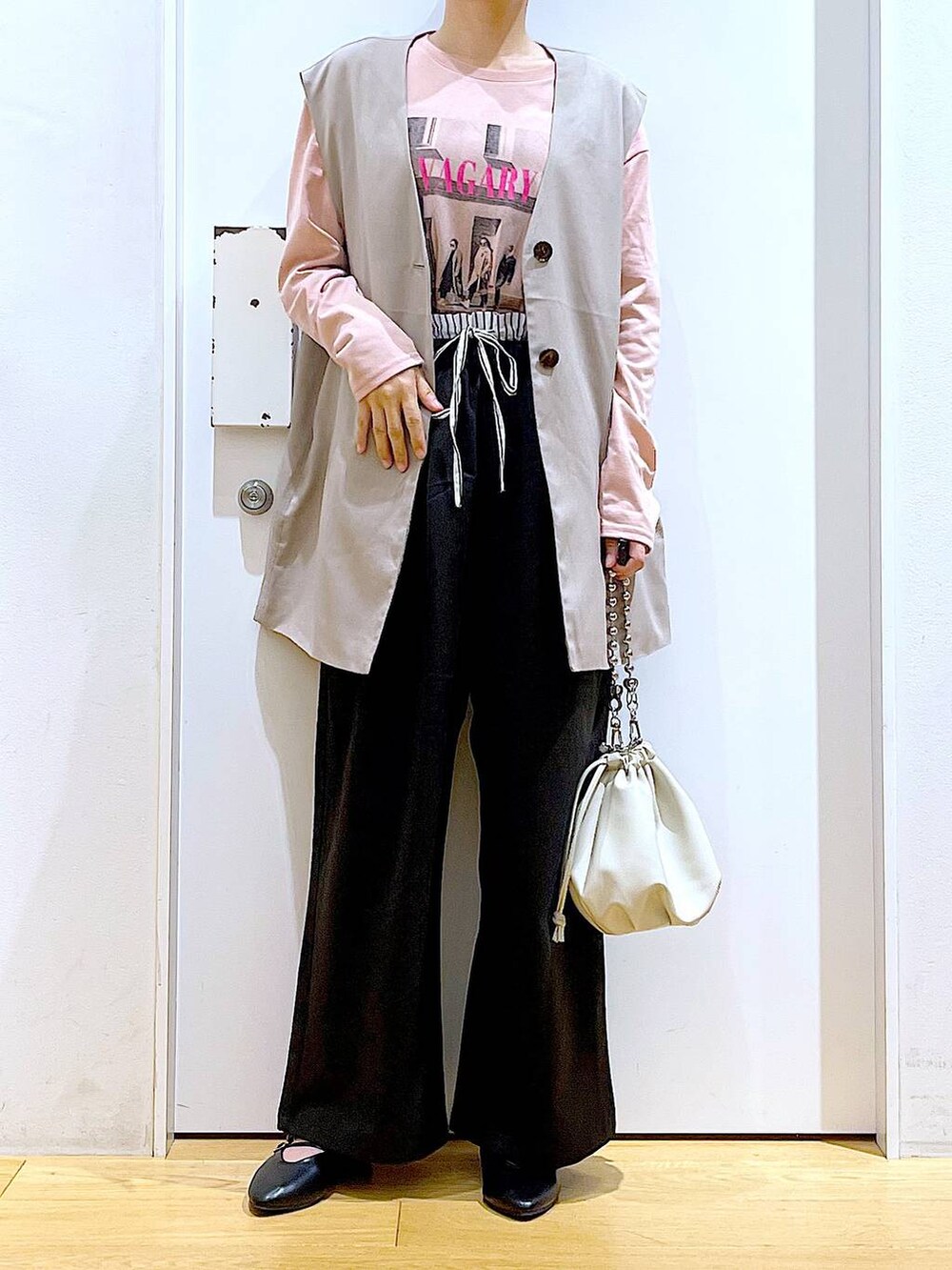 ベージュ系のショルダーバッグ、ブラック系のパンプス、ベージュ系のベストを着用したレディースの秋コーディネートの6枚目の写真