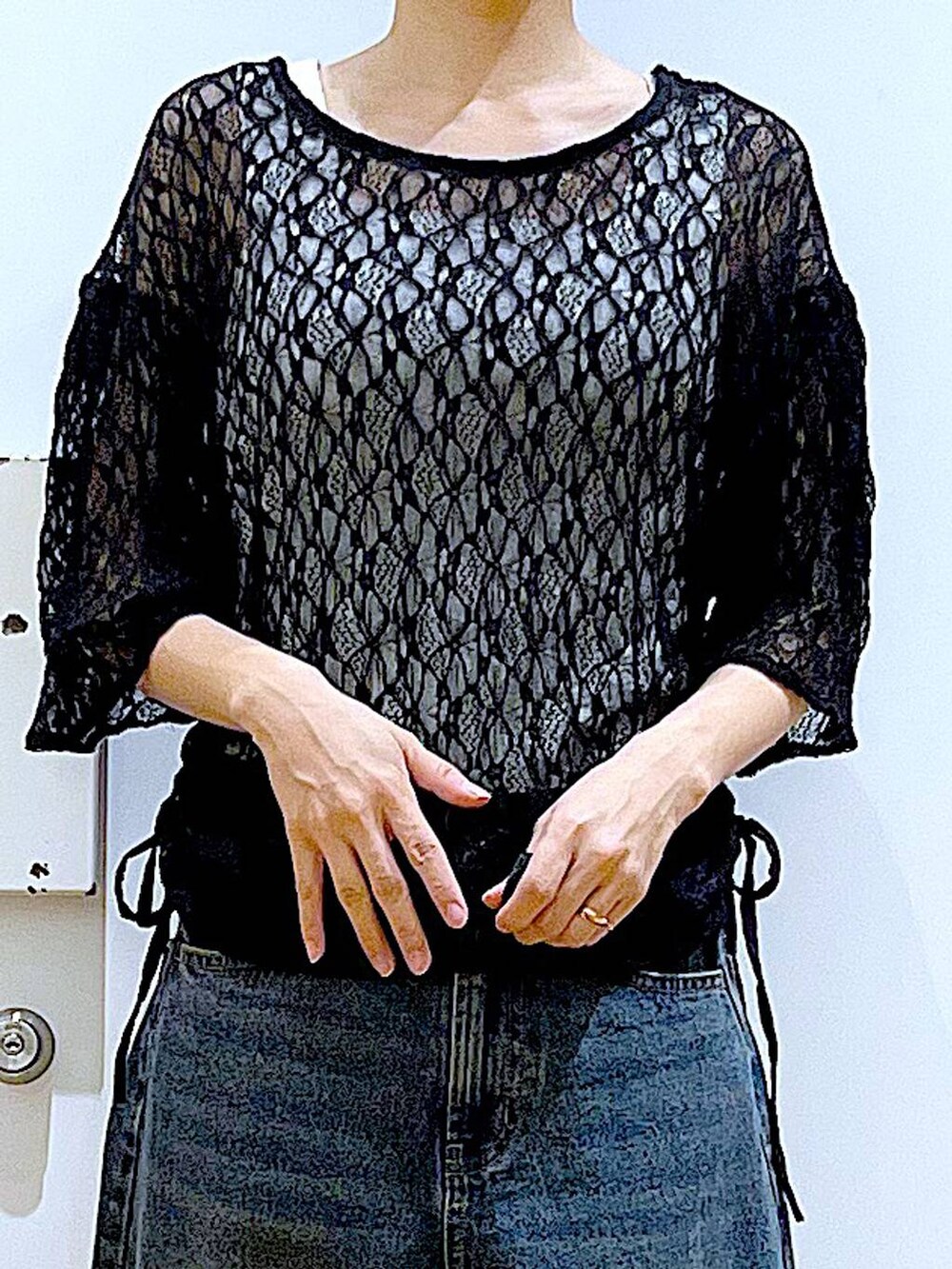 ブルー系のデニムパンツ、シルバー系のパンプス、ブラック系のTシャツ/カットソーを着用したレディースの夏コーディネートの7枚目の写真