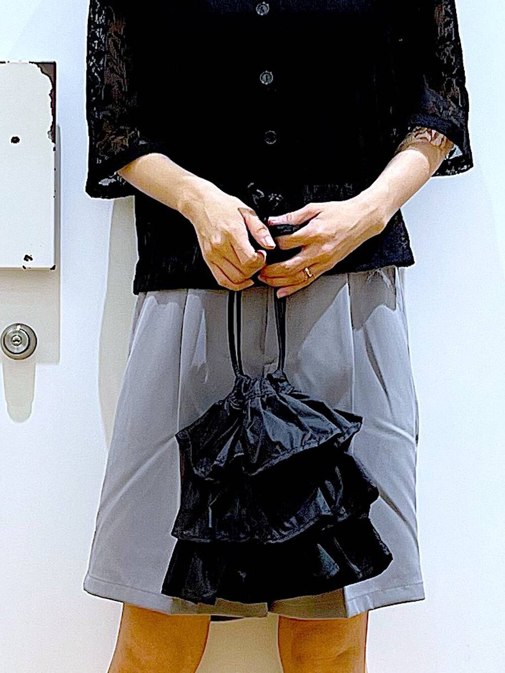 ブラック系のショルダーバッグ、ブラック系のパンプス、グレー系のその他パンツを着用したレディースの夏コーディネートの9枚目の写真