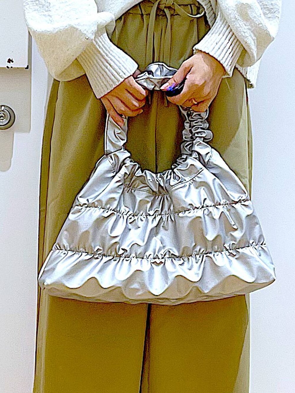 ベージュ系のブーツ、イエロー系のその他パンツ、シルバー系のショルダーバッグを着用したレディースの冬コーディネートの9枚目の写真