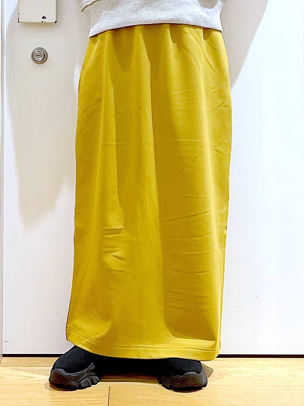 ホワイト系のショルダーバッグ、ブラック系のブーツ、ベージュ系のニット/セーターを着用したレディースの冬コーディネートの8枚目の写真