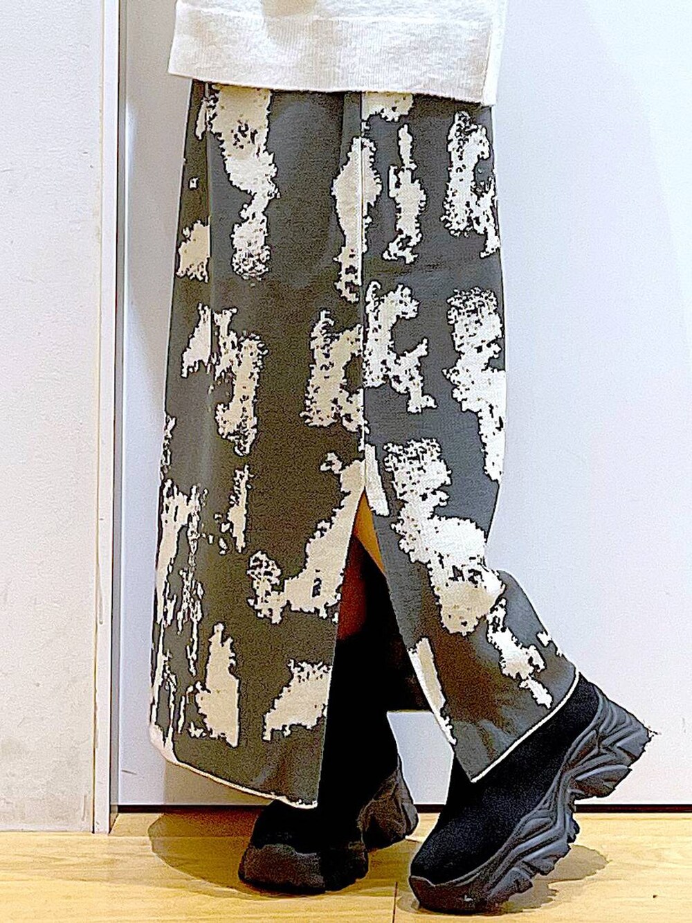 グレー系のスカート、ブラック系のブーツ、ベージュ系のニット/セーターを着用したレディースの秋コーディネートの8枚目の写真