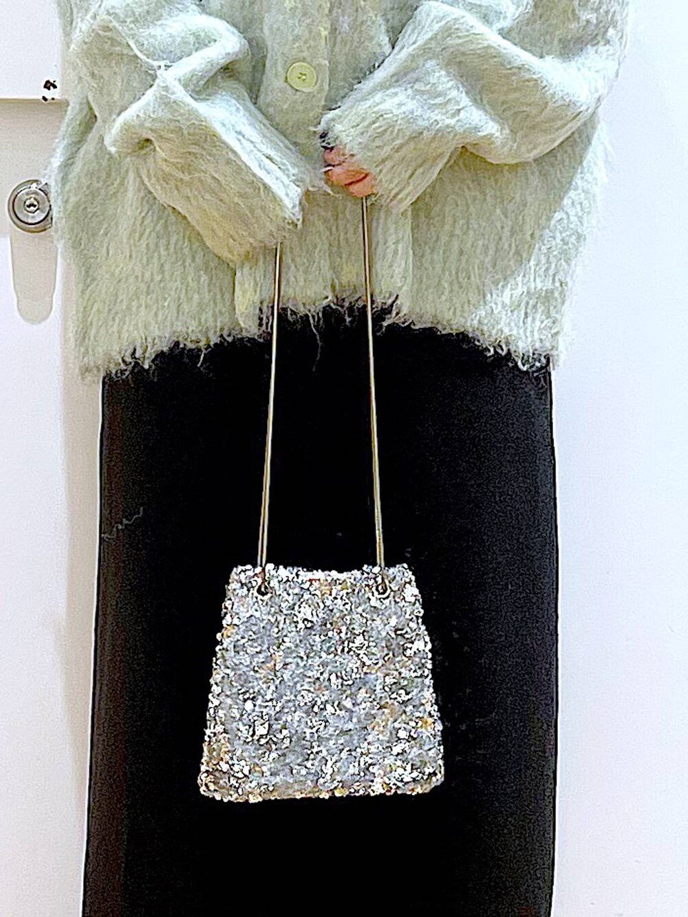 グリーン系のカーディガン/ボレロ、ブラック系のブーツ、ブラック系のスカートを着用したレディースの冬コーディネートの9枚目の写真