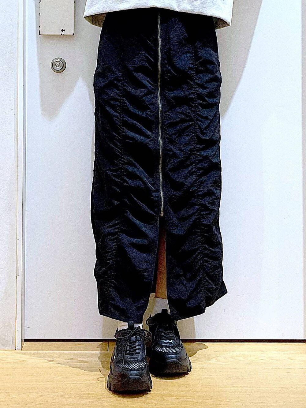 ブラック系のスカート、ブラック系のスニーカー、その他のトートバッグを着用したレディースの春コーディネートの8枚目の写真