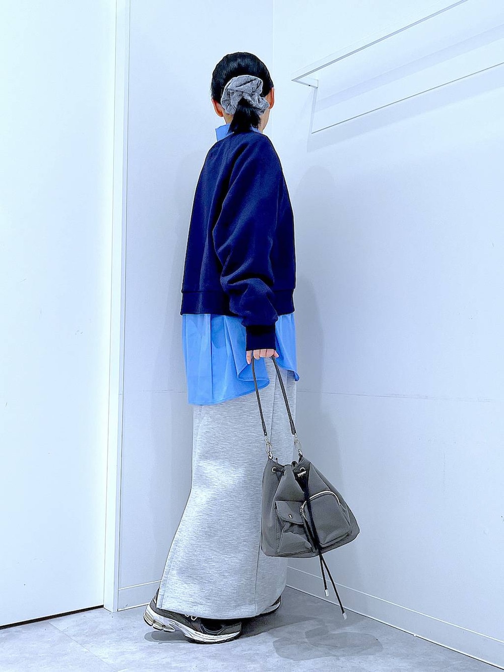 グレー系のショルダーバッグ、グレー系のスカート、ブルー系のシャツ/ブラウスを着用したレディースの春コーディネートの4枚目の写真