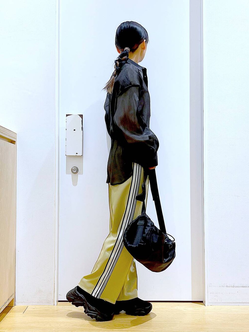 グリーン系のその他パンツ、ブラック系のスニーカー、ブラック系のショルダーバッグを着用したレディースの春コーディネートの4枚目の写真