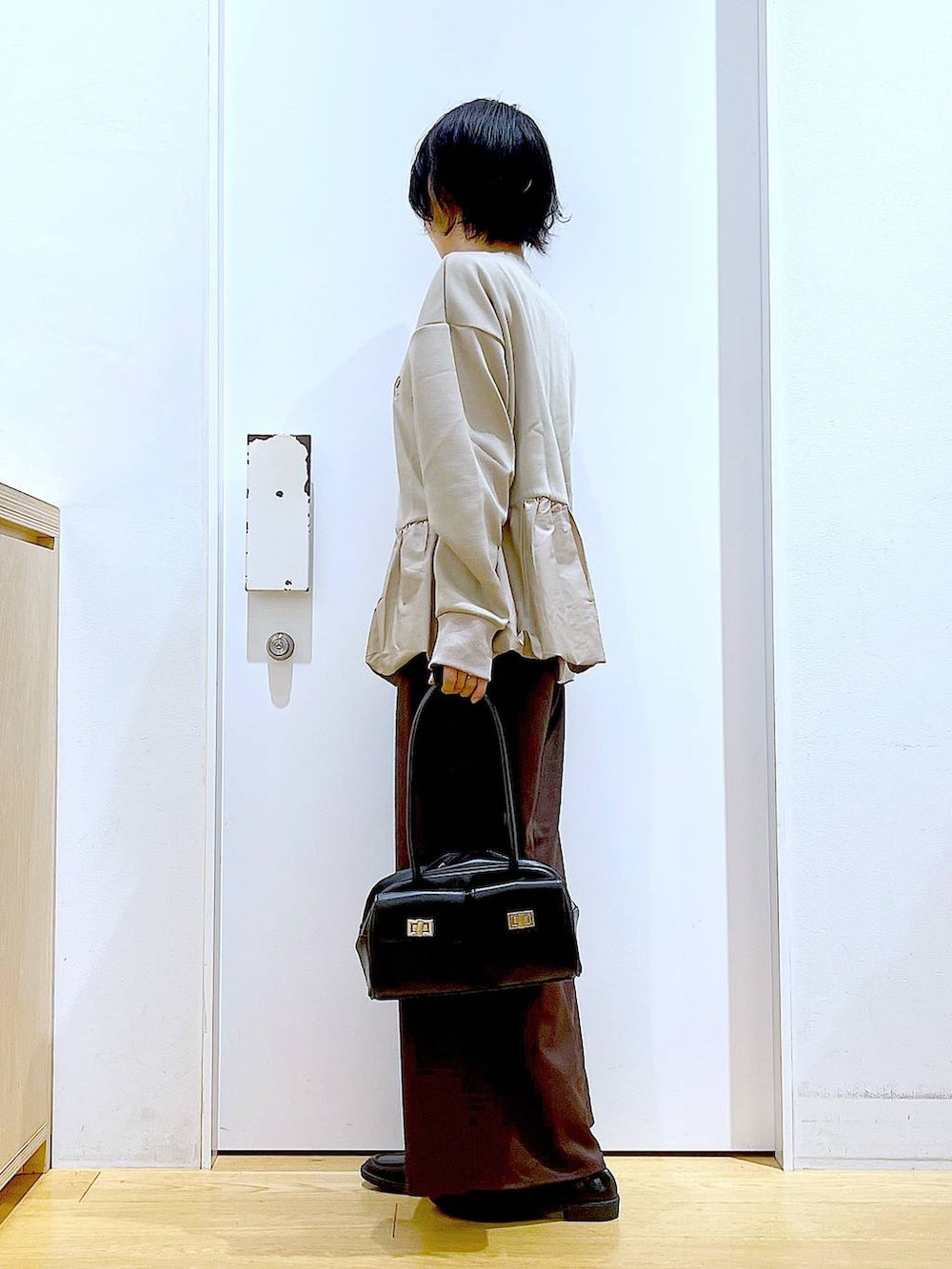 ブラック系のハンドバッグ、ブラウン系のその他パンツ、ブラック系のローファーを着用したレディースの秋コーディネートの3枚目の写真