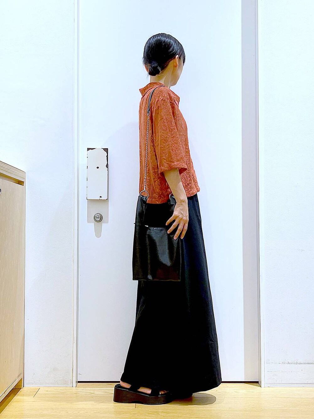 ブラック系のショルダーバッグ、レッド系のシャツ/ブラウス、ブラック系のスカートを着用したレディースの夏コーディネートの4枚目の写真