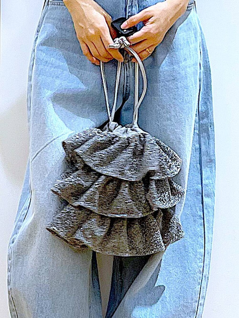 シルバー系のショルダーバッグ、ベージュ系のサンダル、ブルー系のデニムパンツを着用したレディースの夏コーディネートの9枚目の写真