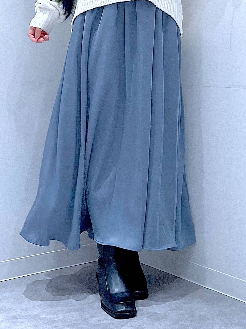 ブラック系のブーツ、ホワイト系のショルダーバッグ、ホワイト系のニット/セーターを着用したレディースの冬コーディネートの8枚目の写真