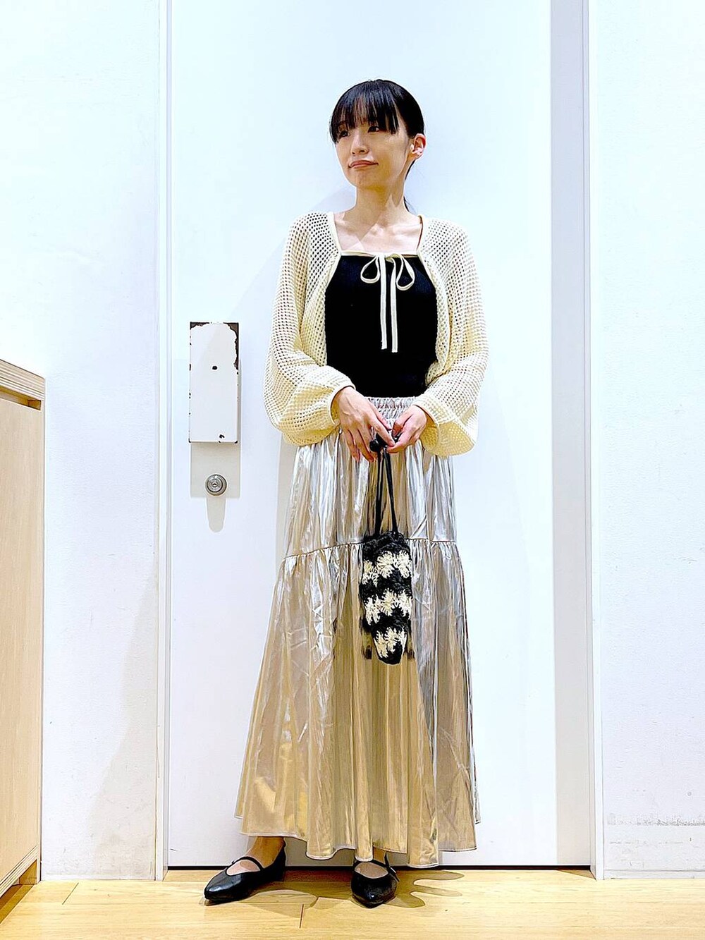 ホワイト系のカーディガン/ボレロ、ブラック系のパンプス、ブラック系のショルダーバッグを着用したレディースの夏コーディネートの2枚目の写真