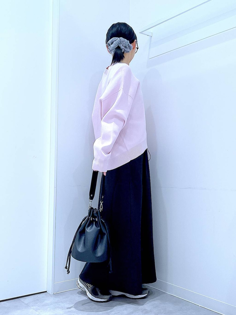 ピンク系のニット/セーター、ブラック系のショルダーバッグ、ブラック系のスカートを着用したレディースの春コーディネートの4枚目の写真