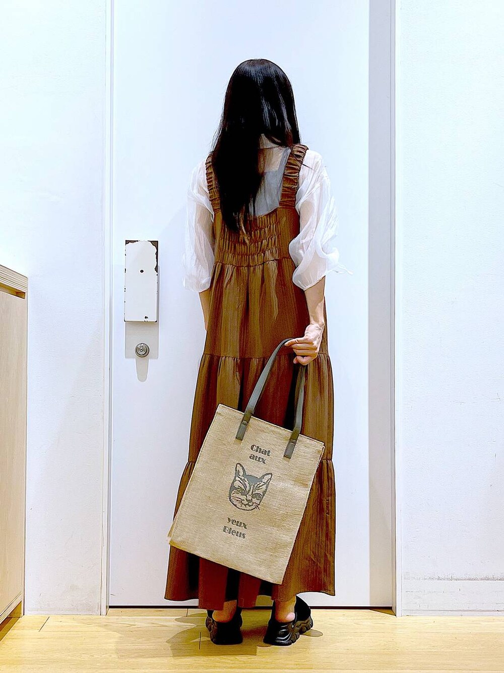 ブラック系のサンダル、ベージュ系のワンピース、グレー系のトートバッグを着用したレディースの夏コーディネートの5枚目の写真