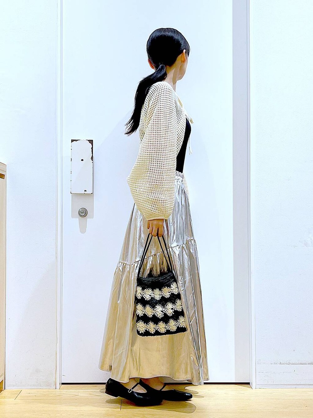 ホワイト系のカーディガン/ボレロ、ブラック系のパンプス、ブラック系のショルダーバッグを着用したレディースの夏コーディネートの4枚目の写真