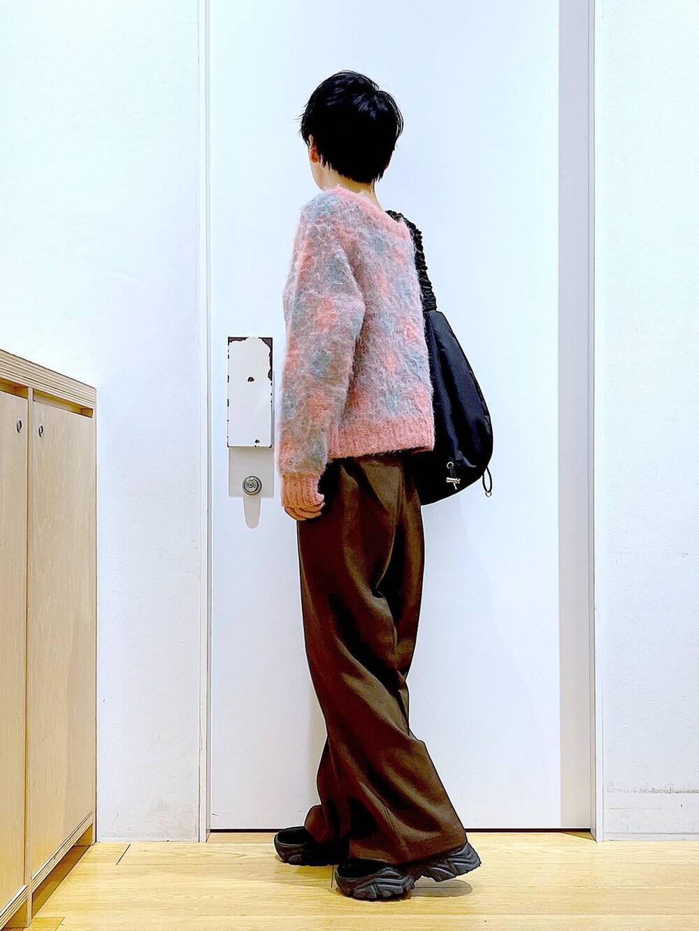 ブラック系のブーツ、ブラック系のショルダーバッグ、ピンク系のニット/セーターを着用したレディースの冬コーディネートの3枚目の写真