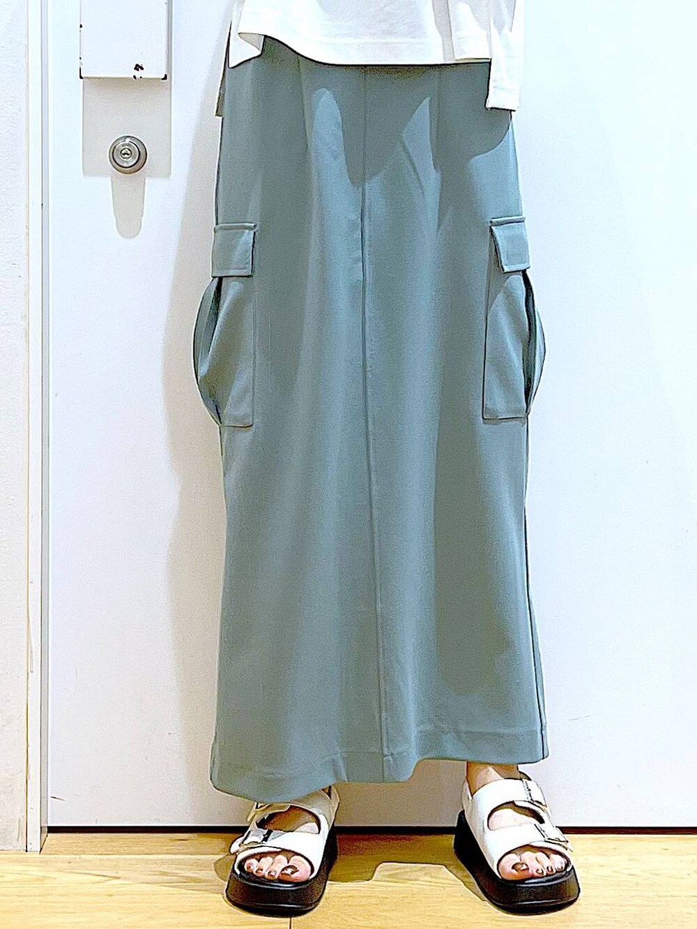 ホワイト系のサンダル、グリーン系のスカート、ブラウン系のトートバッグを着用したレディースの夏コーディネートの8枚目の写真