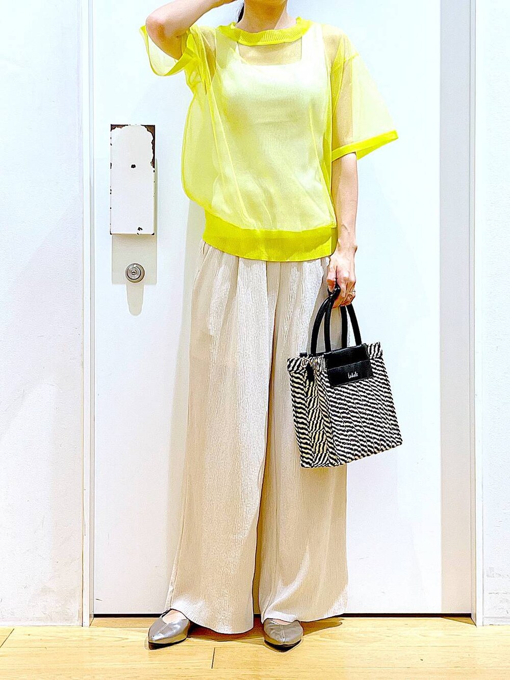 イエロー系のニット/セーター、ホワイト系のその他パンツ、ホワイト系のニット/セーターを着用したレディースの夏コーディネートの6枚目の写真