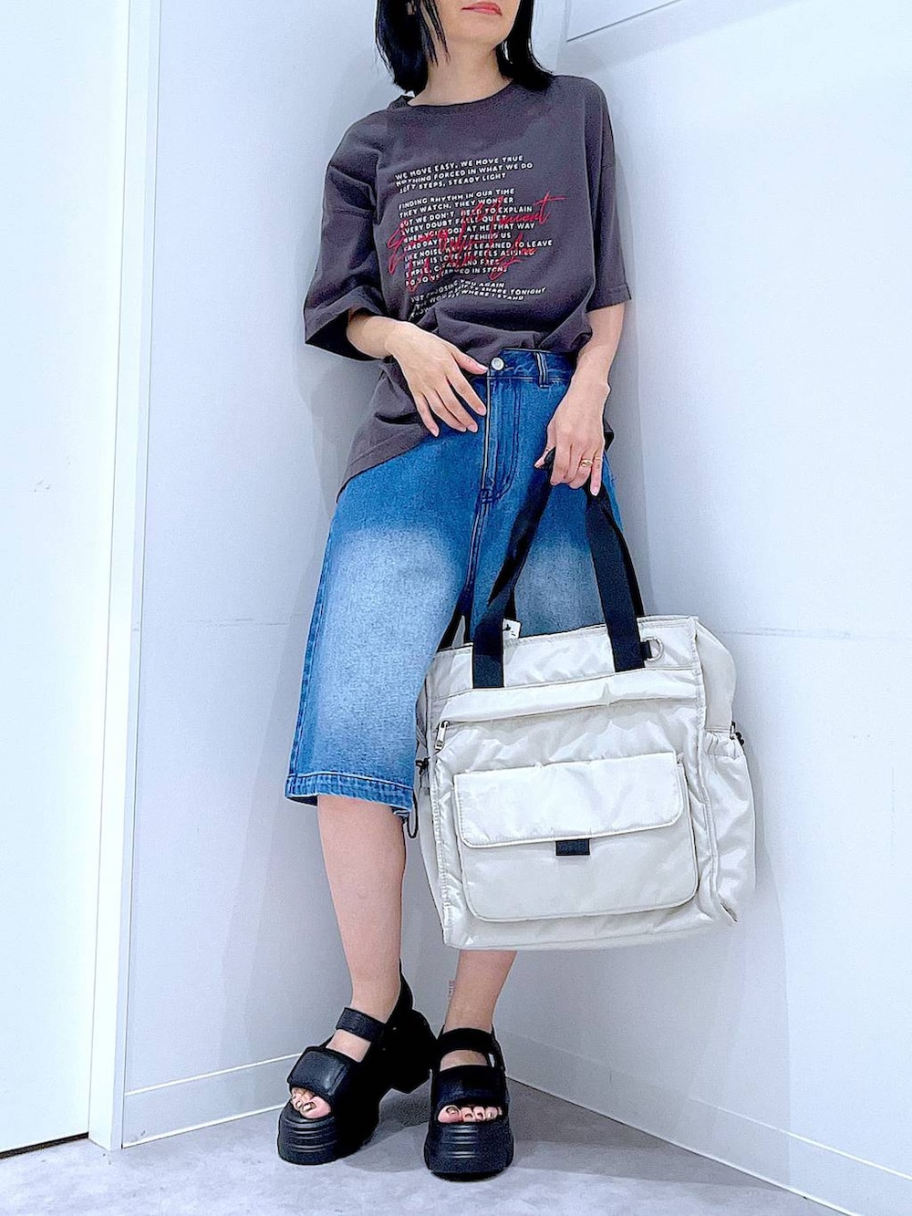 ブラック系のサンダル、ホワイト系のトートバッグ、グレー系のTシャツ/カットソーを着用したレディースの夏コーディネートの6枚目の写真
