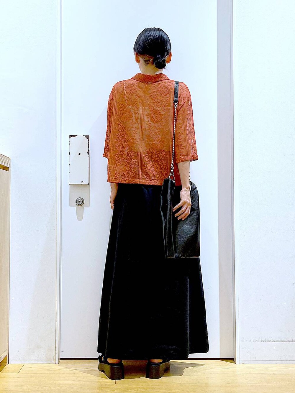 ブラック系のショルダーバッグ、レッド系のシャツ/ブラウス、ブラック系のスカートを着用したレディースの夏コーディネートの5枚目の写真