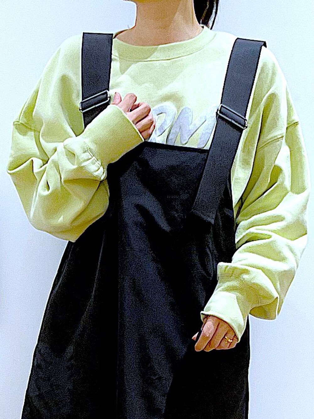 イエロー系のスウェット、ベージュ系のブーツ、その他のショルダーバッグを着用したレディースの冬コーディネートの7枚目の写真