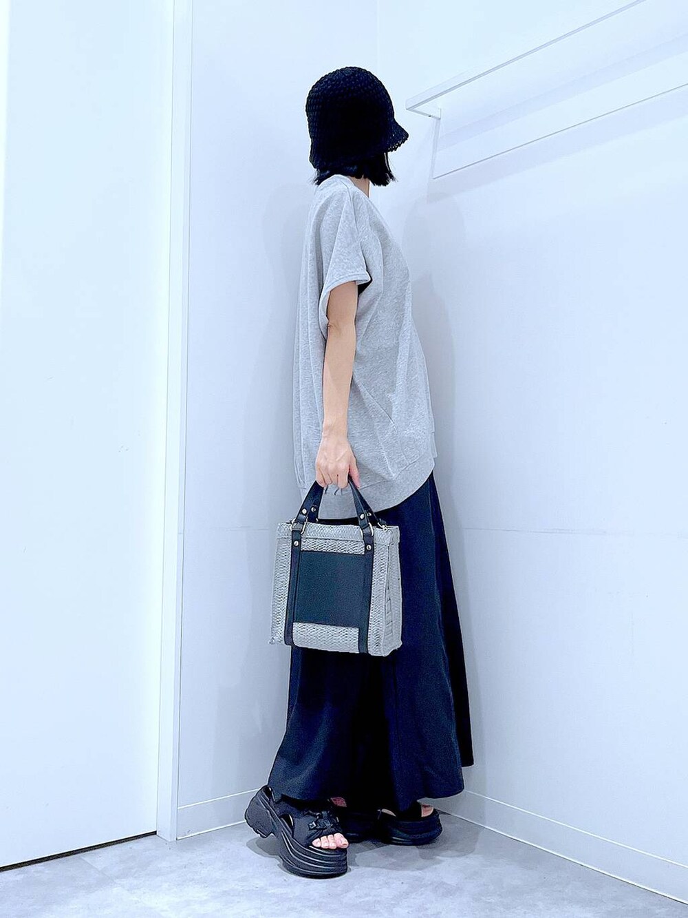 グレー系のショルダーバッグ、ブラック系のサンダル、グレー系のTシャツ/カットソーを着用したレディースの夏コーディネートの4枚目の写真